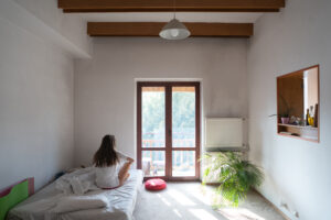 Young Woman Sitting Bed Looking Through Window